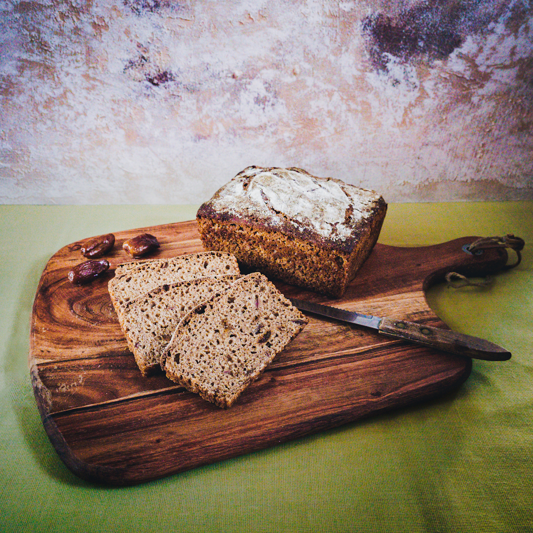 bochenek chleba i kromki na drewnianej desce