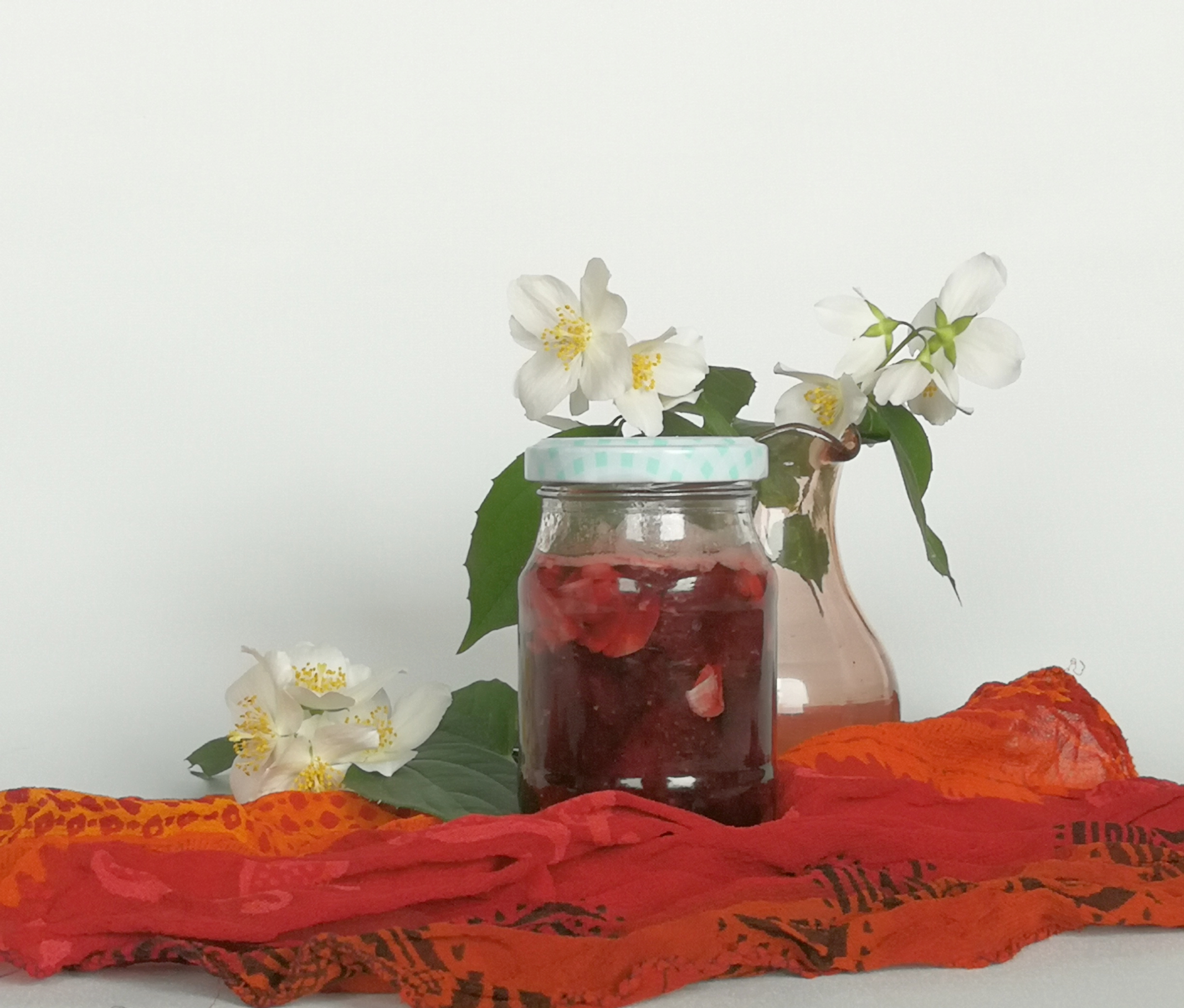 konfitura truskawkowa z płatkami jaśminu, gałązki z kwiatami w tle